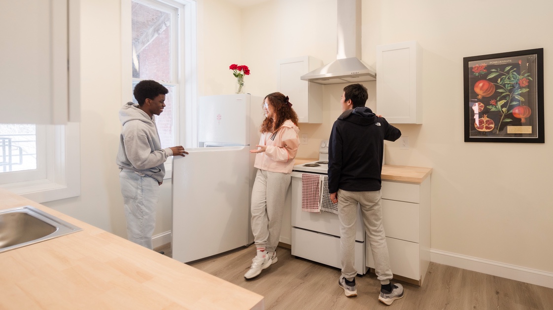 Three students in residence hall kitchen
