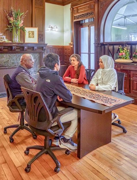 Three students meeting with professor